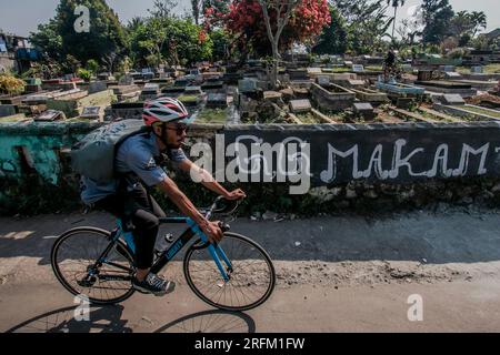 Bogor, Indonésie - 01 août 2023 : les cyclistes marchent dans un cimetière à Bogor, Java Ouest. Banque D'Images