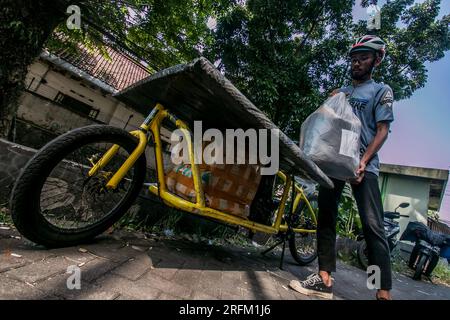 Bogor, Indonésie - 01 août 2023 : un transporteur à vélos transporte un paquet de marchandises sur un vélo cargo à livrer à l'adresse du client à Bogor Banque D'Images