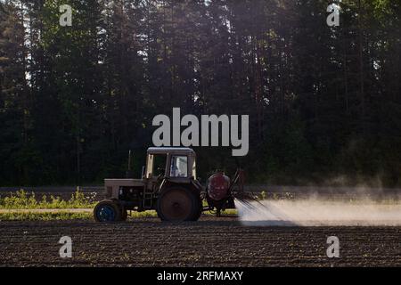 Pulvérisateur de récolte avec tracteur agricole pour appliquer des pesticides dans un champ agricole. Banque D'Images