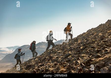 Groupe de jeunes randonneurs marche avec des sacs à dos en montée ensemble. Concept de tourisme actif Banque D'Images