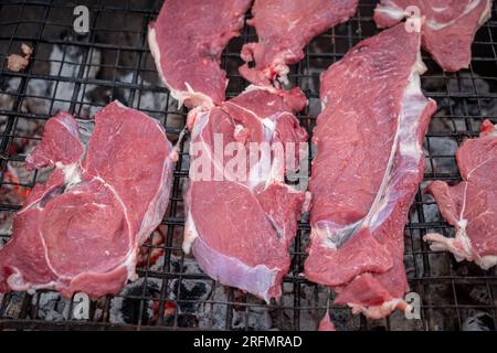 morceaux de bœuf cru préparés pour rôtir sur un gril à charbon de bois Banque D'Images