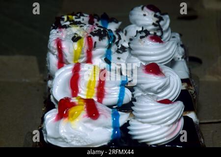 Diverses tranches de gâteaux, gâteau arc-en-ciel, gâteau aux framboises et gâteau aux amandes. Bonbons décorés avec pour les vacances Banque D'Images