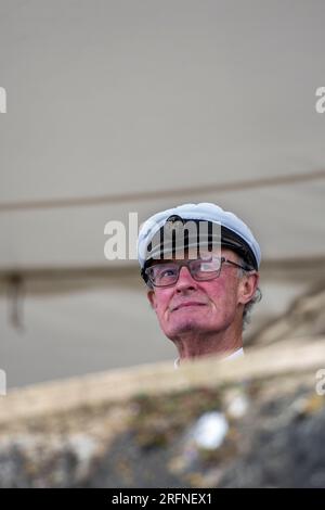 membre de l'escadron royal de yachts à cowes portant un chapeau de capitaine regardant depuis le balcon en regardant la régate pendant la semaine cowes Banque D'Images