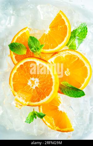 Tranches d'orange juteuses fraîches avec menthe et glace. Vue de dessus, gros plan. Banque D'Images