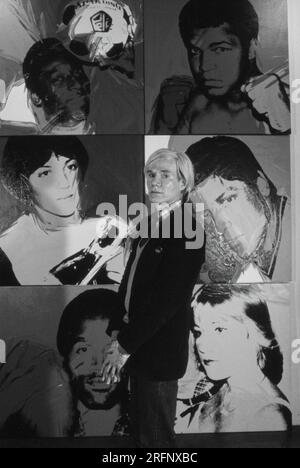 Andy Warhol dans une galerie de New York avec ses portraits d'art en 1975. Warhol était un artiste visuel américain, réalisateur, producteur et figure de proue du mouvement pop art. Ses œuvres explorent la relation entre l'expression artistique, la publicité et la culture des célébrités qui a prospéré dans les années 1960, et couvrent une variété de médias, y compris la peinture, la sérigraphie, la photographie, le cinéma, et sculpture. Parmi ses œuvres les plus connues figurent les peintures sérigraphiées Campbell's Soup Cans et Marilyn diptyque. Photo de Bernard Gotfryd Banque D'Images