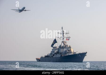 GOLFE ARABIQUE (3 août 2023) le destroyer de missiles guidés USS McFaul (DDG 74) participe à un exercice photo avec un avion P-8 Poseidon dans le Golfe Arabique, le 3 août 2023. McFaul est déployé dans la zone d'opérations de la 5e flotte américaine pour aider à assurer la sécurité et la stabilité maritimes dans la région du Moyen-Orient. (ÉTATS-UNIS Photo de Juel Foster, spécialiste en communication de masse de 2e classe) Banque D'Images