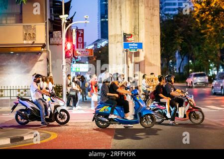 Motos et cyclomoteurs attendent à un carrefour dans le centre-ville animé de Silom à Bangkok, Thaïlande. Banque D'Images