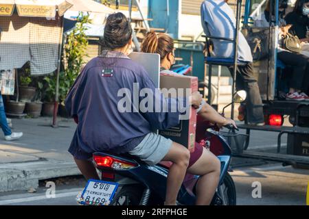 SAMUT PRAKAN, THAÏLANDE, JANVIER 28 2023, deux femmes transportent une cargaison sur une moto Banque D'Images