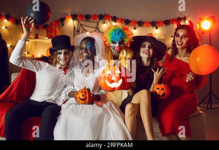 Portrait d'amis fous joyeux dans divers costumes effrayants à la fête d'Halloween amusante à la maison. Banque D'Images