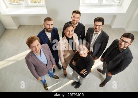 Vue de dessus d'un groupe de gens d'affaires regardant la caméra et souriant. Banque D'Images