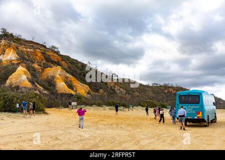 Fraser Island K'gari, bus touristique explorateur sur la plage de 75 miles aux Pinnacles alors que les touristes regardaient les sables colorés, Queensland, Australie Banque D'Images