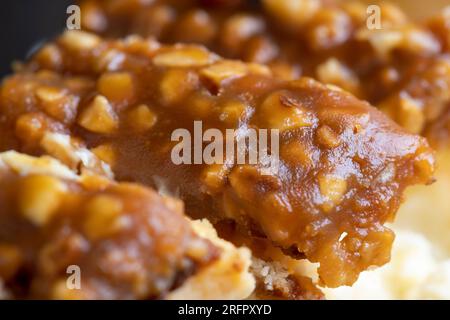 Cheesecake à base de produits laitiers et de cacahuètes au caramel, délicieux dessert aux cacahuètes coupées en morceaux pour le thé dans un café Banque D'Images