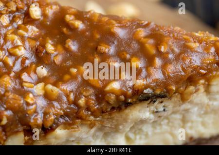 Cheesecake à base de produits laitiers et de cacahuètes au caramel, délicieux dessert aux cacahuètes coupées en morceaux pour le thé dans un café Banque D'Images