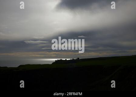 Photographie couleur du château de Dunnottar en silhouette et nuages dramatiques, près de Stonehaven, Écosse, Royaume-Uni, 2022. Banque D'Images