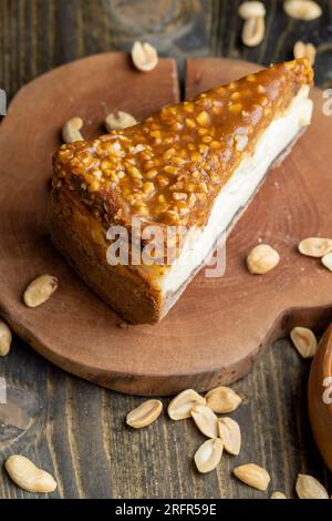 Cheesecake à base de produits laitiers et de cacahuètes au caramel, délicieux dessert aux cacahuètes coupées en morceaux pour le thé dans un café Banque D'Images
