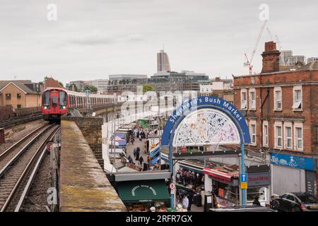 Un train de métro Hammersmith et City Line passant Shepherds Bush Market - un marché de rue à Shepherd's Bush, West London, Angleterre, Royaume-Uni Banque D'Images