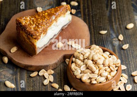 Cheesecake à base de produits laitiers et de cacahuètes au caramel, délicieux dessert aux cacahuètes coupées en morceaux pour le thé dans un café Banque D'Images