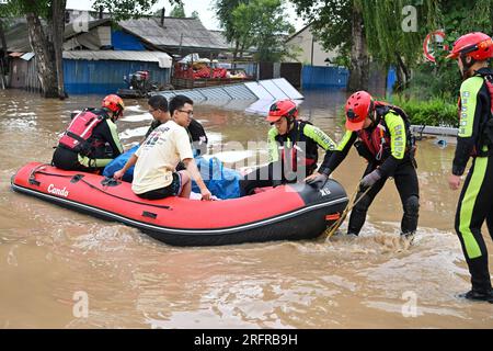 (230805) -- HARBIN, 5 août 2023 (Xinhua) -- des pompiers transfèrent des résidents bloqués dans le comté de Yanshou de Harbin, dans la province du Heilongjiang, dans le nord-est de la Chine, le 5 août 2023. Déclenchés par des pluies torrentielles dans la ville de Mudanjiang et la capitale provinciale Harbin, les niveaux d'eau de certains fleuves ont dépassé le niveau d'alerte. Des équipes de secours d'urgence, y compris des pompiers locaux et des pompiers forestiers, ont été dépêchées pour aider aux travaux de sauvetage et de secours. Les patrouilles de 24 heures sur 24 sur les remblais ont été effectuées pour maîtriser les risques, et les habitants touchés par les inondations ont été relocalisés Banque D'Images