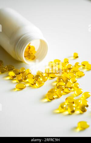 Capsules d'huile de poisson avec oméga 3 sur table blanche. Concept d'alimentation saine. Suppléments de gel doux remplis pour l'alimentation. Concept de soins de santé. Banque D'Images