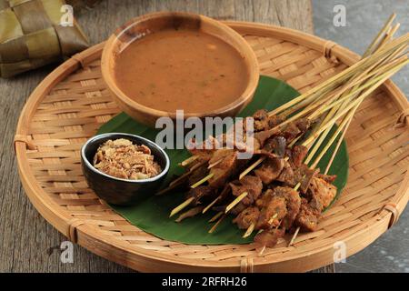 Sate Padang ou Satay Padang, bœuf épicé Satay de Padang, Sumatra Ouest. Servi avec sauce curry épicée et gâteau de riz Ketupat, Lontong sur feuille de banane. Banque D'Images