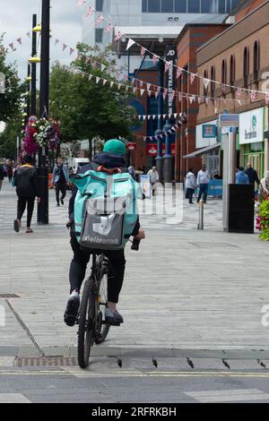 Slough, Berkshire, Royaume-Uni. 3 août 2023. Un pilote Deliveroo à Slough High Street, Berkshire. Le secrétaire d'État au travail et aux pensions, Mel Stride, a déclaré cette semaine, lors d'une visite au siège de Deliveroo à Londres, que plus de 50 ans devraient envisager des emplois flexibles comme la livraison de plats à emporter. Deliveroo a enregistré une augmentation de 62% du nombre de coureurs âgés de plus de 50 ans depuis 2021. Crédit : Maureen McLean/Alamy Banque D'Images