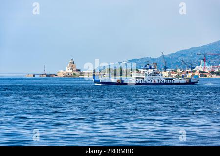 Ferry MF Archimede traversant le détroit de Messine depuis le port de Messine, avec le phare de San Ranieri en arrière-plan, Messine, Sicile, Italie Banque D'Images