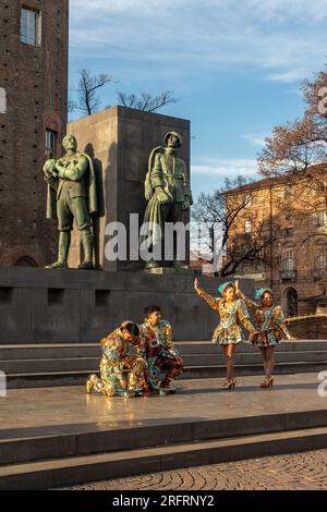 Danseurs boliviens en costumes traditionnels sur la Piazza Castello devant le monument au duc d'Aoste (1937), Turin, Piémont, Italie Banque D'Images