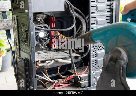 Photographie d'un technicien qui souffle de la poussière sur un ordinateur Banque D'Images