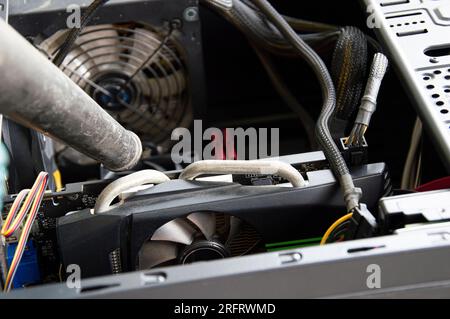 Photographie d'un technicien qui souffle de la poussière sur un ordinateur Banque D'Images