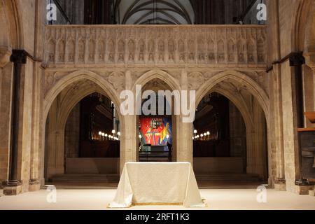 L'autel vu de l'entrée voûtée en pierre du chœur et au-delà dans la cathédrale de Chichester. Banque D'Images