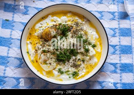 Cilbir d'œufs pochés turcs servi sur un délicieux yaourt garliqué, et fini avec un beurre épicé chaud et l'aneth. Banque D'Images