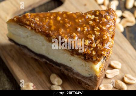 Cheesecake à base de produits laitiers et de cacahuètes au caramel, délicieux dessert aux cacahuètes coupées en morceaux pour le thé dans un café Banque D'Images