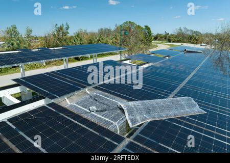 Détruit par le vent ouragan panneaux solaires photovoltaïques montés sur le toit de carport pour produire de l'électricité écologique verte pour la recharge des véhicules électriques Banque D'Images