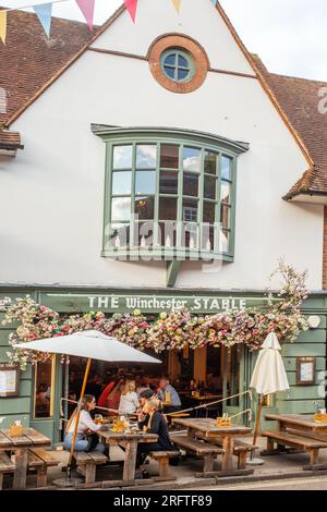 Les gens étaient assis dehors manger et boire à la Winchester stable dans la ville du Hampshire de Winchester Angleterre Royaume-Uni Banque D'Images