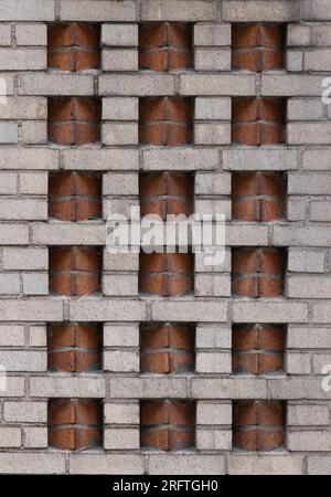 motif de brique décorative art déco à deux tons dans un mur de briques beiges avec des inserts de briques de couleur terre cuite dans un placement en dents de scie créent une géométrie Banque D'Images