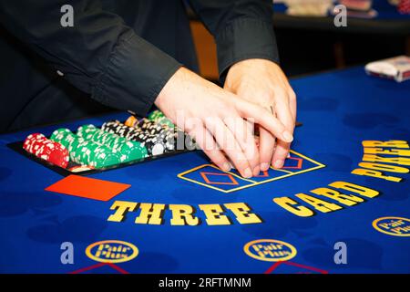 Les mains du croupier de table de poker se rapprochent Banque D'Images