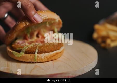Hamburgers de poulet sur plaque en bois Banque D'Images
