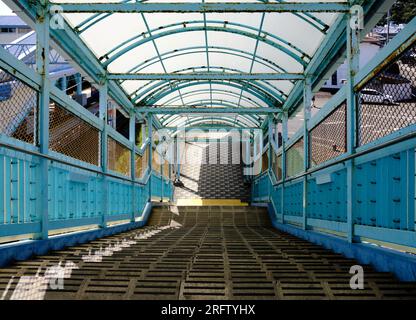 Passerelle couverte en métal bleu descendant les escaliers avec photo de toit menant à l'infini Banque D'Images