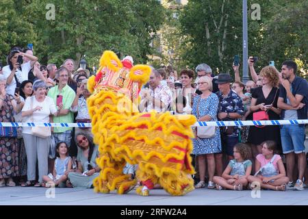 Madrid, Espagne. 5 août 2023. Les gens regardent danser le lion sur la Plaza de Oriente (place de l’est) à Madrid, en Espagne, le 5 août 2023. La troupe de danse du Lion Shenzhen Fuyong Huaide s'est produite dans les rues de Madrid du vendredi au dimanche à l'invitation du Festival de Madrid l'été dans la ville et du Centre culturel chinois de Madrid. Crédit : Meng Dingbo/Xinhua/Alamy Live News Banque D'Images
