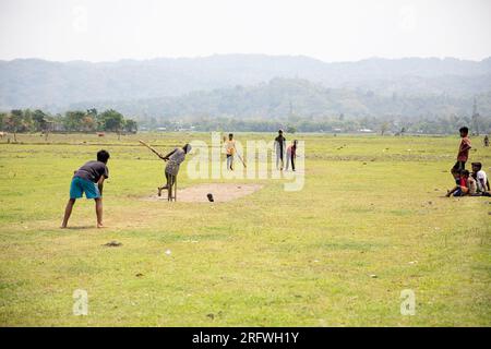 Garçons jouant au cricket sur le terrain Banque D'Images