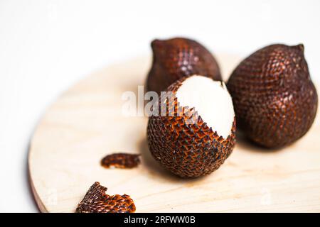 Salak ou fruit de serpent dans la plaque de bois isolé sur fond blanc. Banque D'Images