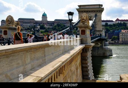 Vue en perspective du pont des chaînes rénové. Bateau d'excursion sur le Danube. Le château de Buda en arrière-plan. la rouvrir au public, les gens marchent. Banque D'Images