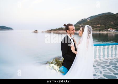 Ein liebevolles Brautpaar genießt die Hochzeit mit Meeresblick Banque D'Images