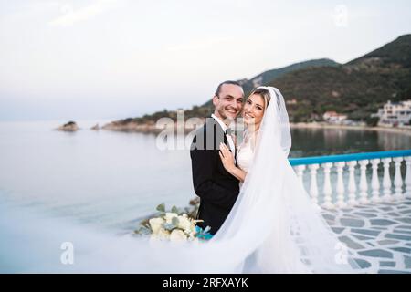 Ein liebevolles Brautpaar genießt die Hochzeit mit Meeresblick Banque D'Images