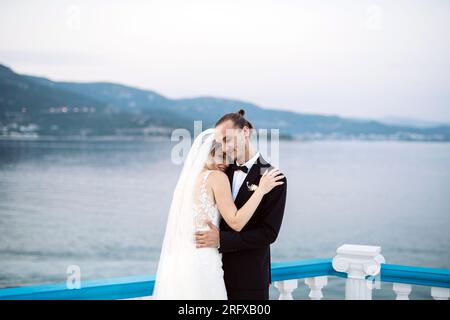 Ein liebevolles Brautpaar genießt die Hochzeit mit Meeresblick Banque D'Images