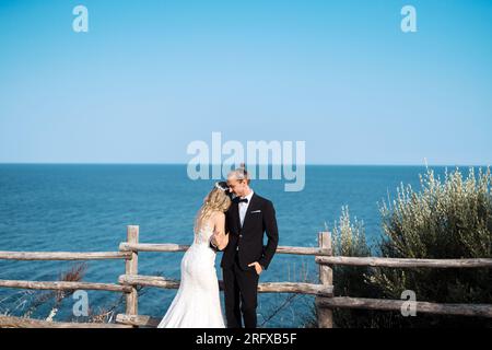 Ein liebevolles Brautpaar genießt die Hochzeit mit Meeresblick Banque D'Images