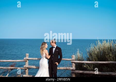 Ein liebevolles Brautpaar genießt die Hochzeit mit Meeresblick Banque D'Images