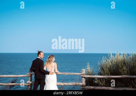 Ein liebevolles Brautpaar genießt die Hochzeit mit Meeresblick Banque D'Images