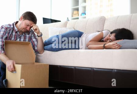 Portrait d'une jeune femme afro-américaine épuisée faisant la sieste sur le canapé Banque D'Images