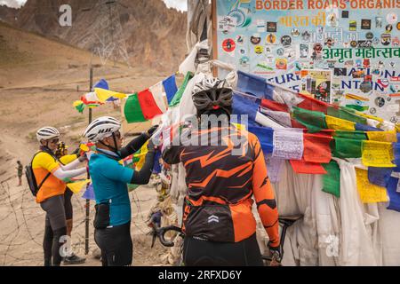 Inde, J&K, Ladakh, Fotu la, Pass, Cyclistes indiens sur Srinager à Leh monter suspendu drapeau de prière bouddhiste Banque D'Images